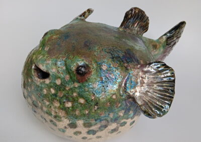 Raku-fired clay pufferfish sculpture with iridescent green and silver glaze by Key West artist Will Fernandez, 14x15 inches.